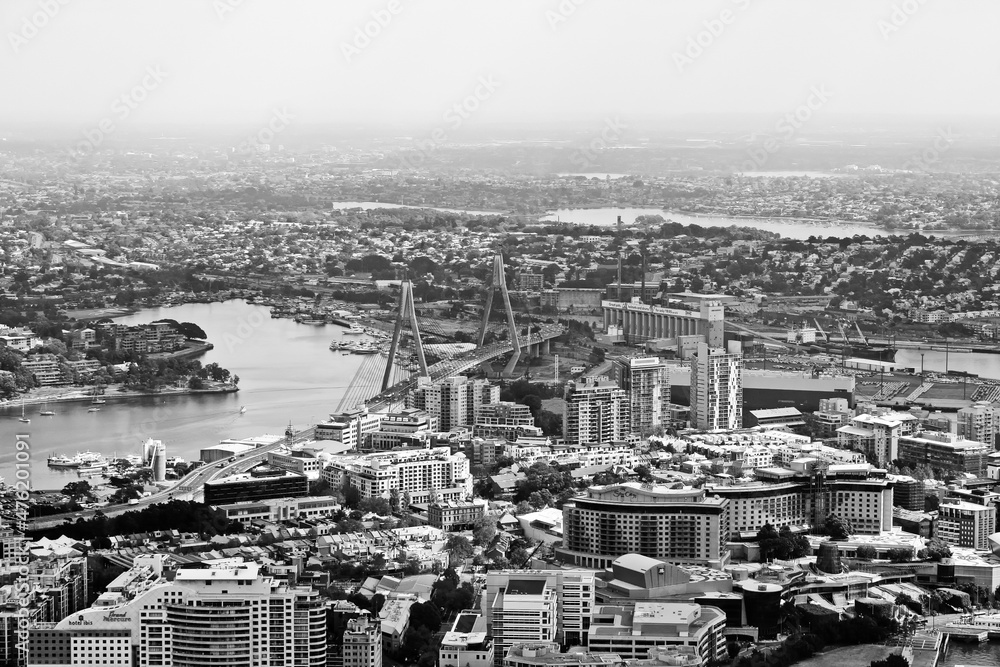 Landscape view of city from top in black and white. Low angle view of big city and harbor in black and white.	