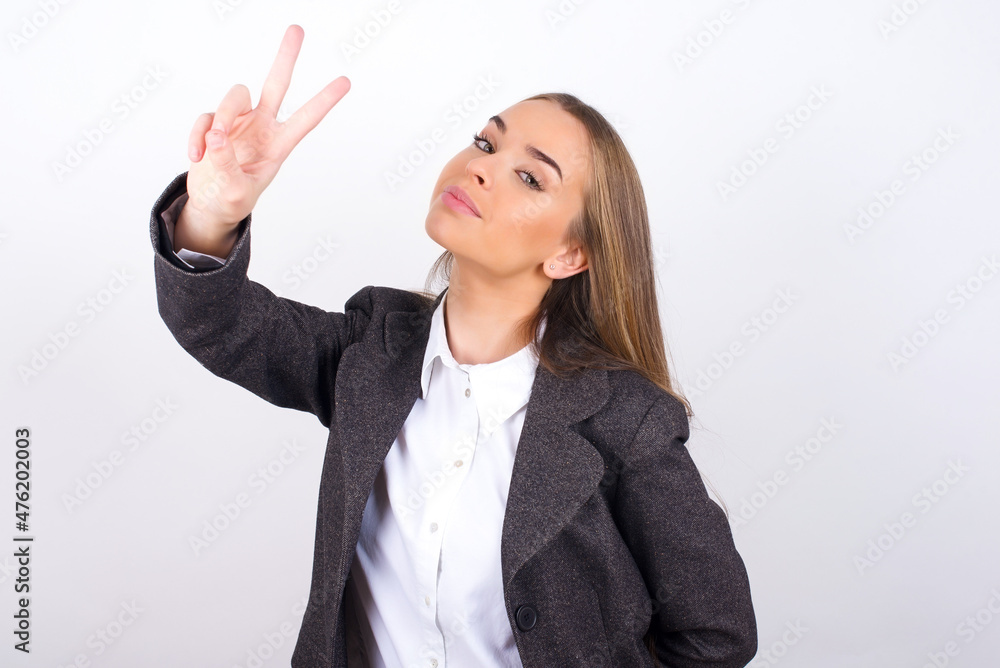 Young business woman wearing jacket over white background directs fingers at camera selects someone. I recommend you. Best choice Young business woman wearing jacket over white background directs fingers at camera selects someone. I recommend you. Best choice