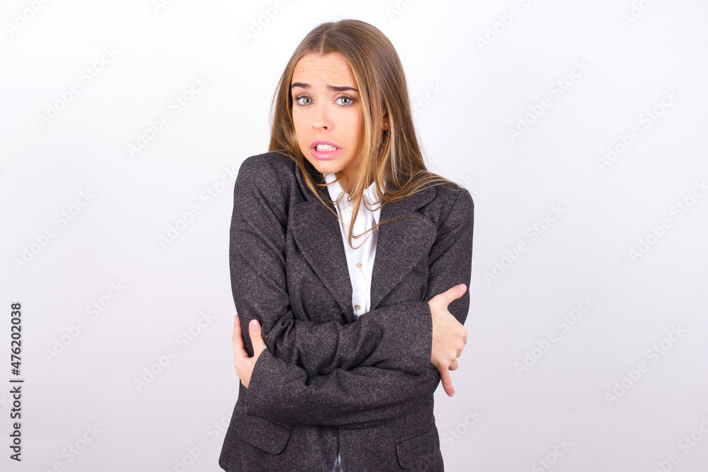 Ταπετσαρία Young business woman wearing jacket over white background shaking and freezing for winter cold with sad and shock expression on face