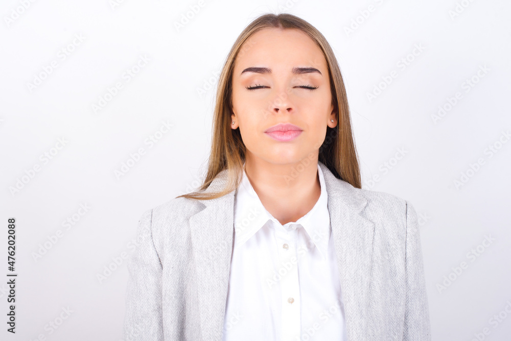 Young business woman wearing jacket over white background nice-looking sweet charming cute attractive lovely winsome sweet peaceful closed eyes Young business woman wearing jacket over white background nice-looking sweet charming cute attractive lovely winsome sweet peaceful closed eyes