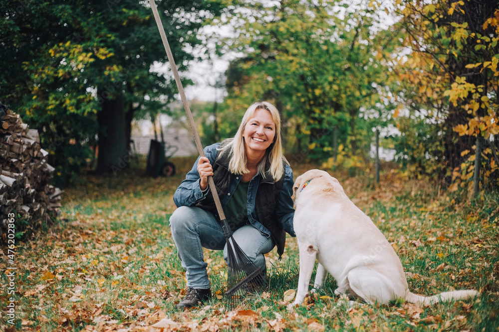 Portrait of smiling woman with dog in backyard Portrait of smiling woman with dog in backyard