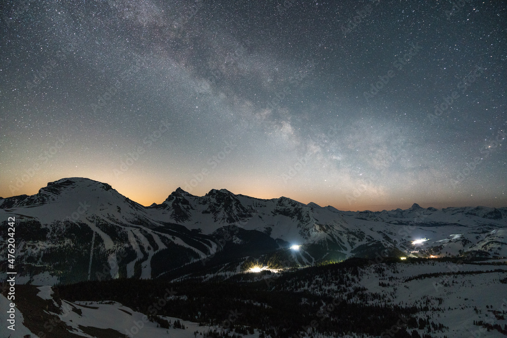 Wonderful starry sky milky way and majestic mountain range in Sunshine Village. Ski village at night. Winter landscape with village in mountains, Banff, Canada