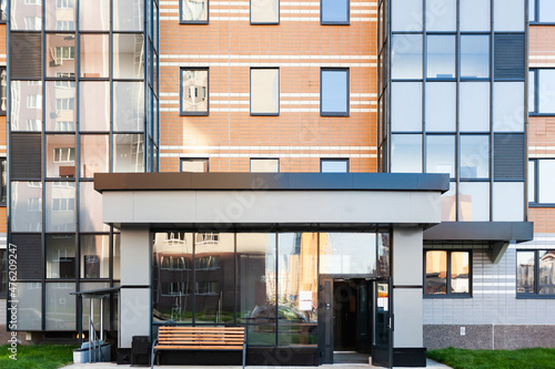 entrance to an apartment building made of glass and metal, modern construction