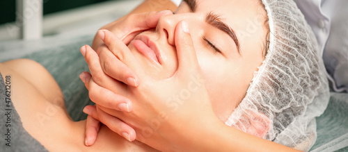 A young caucasian woman getting facial massage in a spa