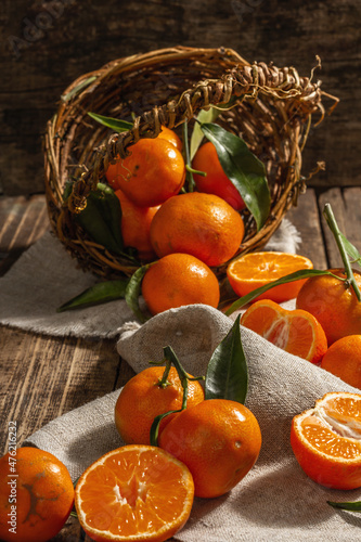 Tangerines falling out of the basket. Oranges  mandarins  clementines  citrus fruits  with leaves