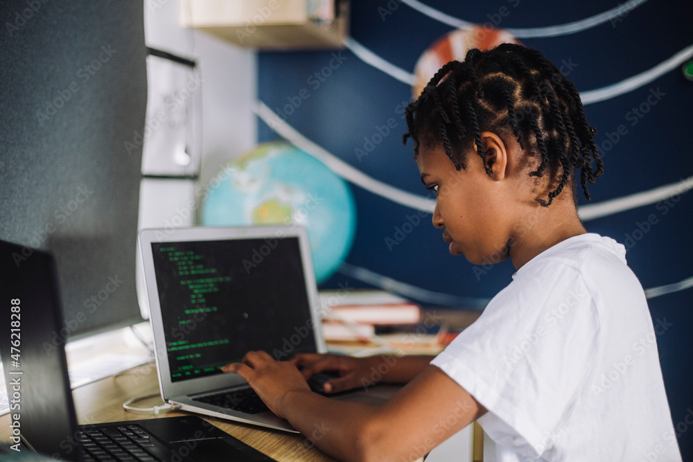 Female student learning coding on laptop at table Female student learning coding on laptop at table