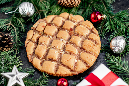 Christmas apple pie with fir and new year decorations on a stone background