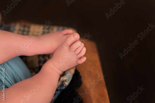 Little infant's feet in a brown bowl