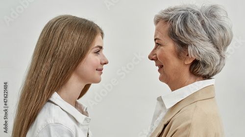 Smiling girl and grandmother looking at each other