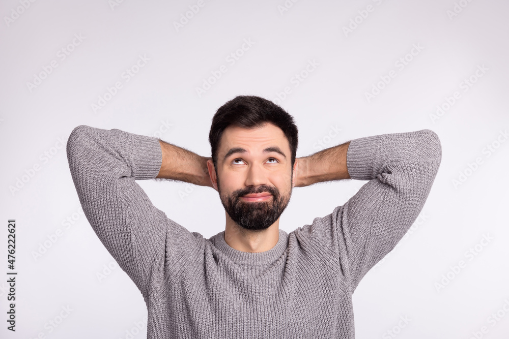 Top above high angle view photo of young man look empty space arms behind head relax isolated over grey color background Top above high angle view photo of young man look empty space arms behind head relax isolated over grey color background