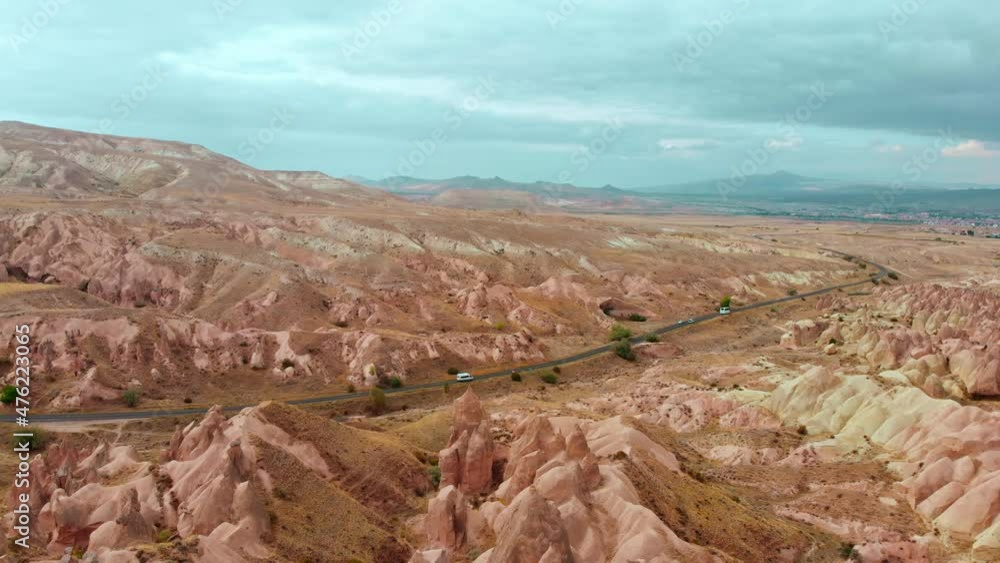 Aerial panoramic view cars buses drive on highway in cappadocia pass devrent valley fairy chimneys background .Travel and tourism in Turkey concept Aerial panoramic view cars buses drive on highway in cappadocia pass devrent valley fairy chimneys background .Travel and tourism in Turkey concept