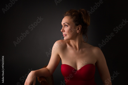portrait of a sensual fifty year old woman on grey studio background