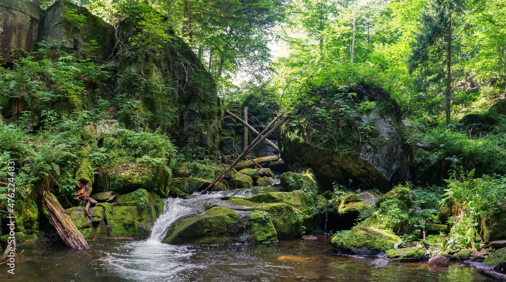 Mountain river in a wild European summer forest. Huge boulders overgrown with green moss Mountain river in a wild European summer forest. Huge boulders overgrown with green moss