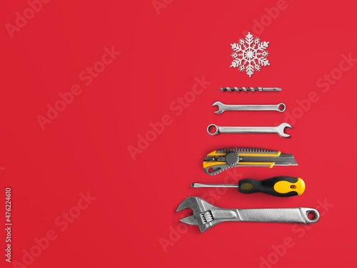 Christmas tree made of construction tools with a snowflake on a background. New Year's concept for a car workshop.