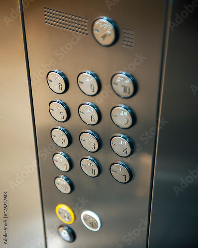 Elevator buttons with selected focus. Vertical closeup photo inside of reflective metal elevator
