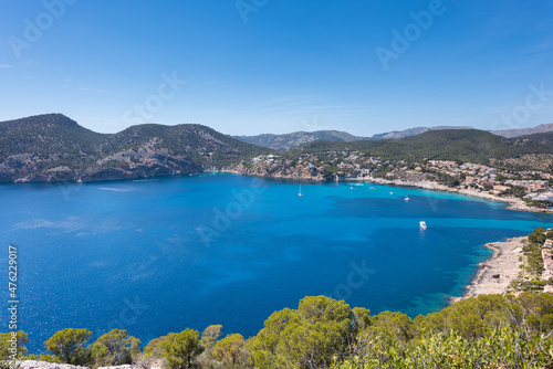 Panoramic of the bay of Camp de Mar, Mallorca. Blue Mediterranean sea and sky. Pine trees around and boats in the sea.
