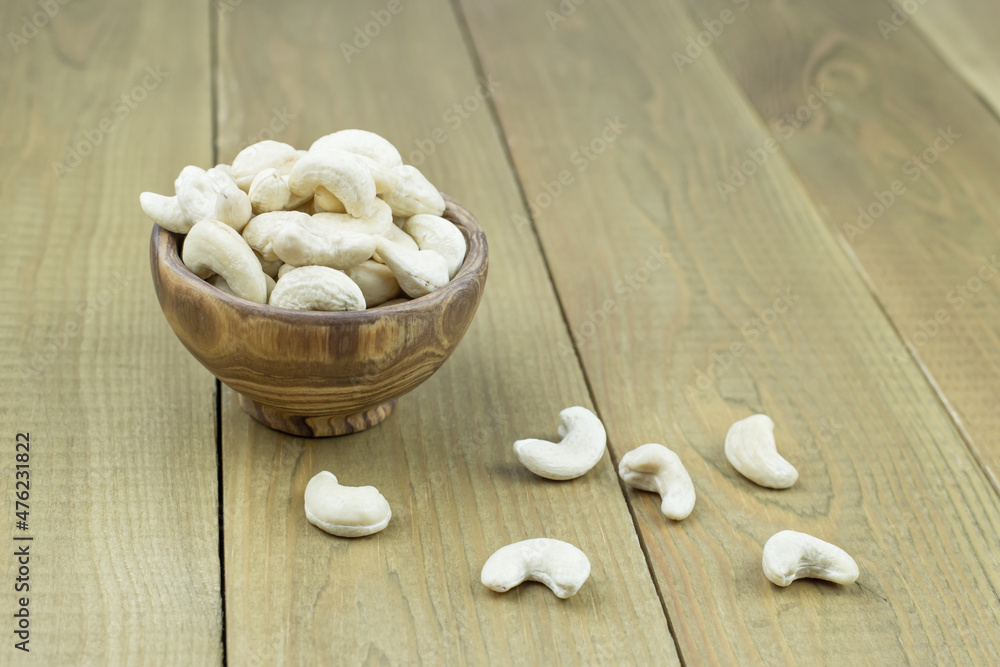 Fresh cashew nuts in a wooden bowl on a light table, Fresh cashew nuts in a wooden bowl on a light table,