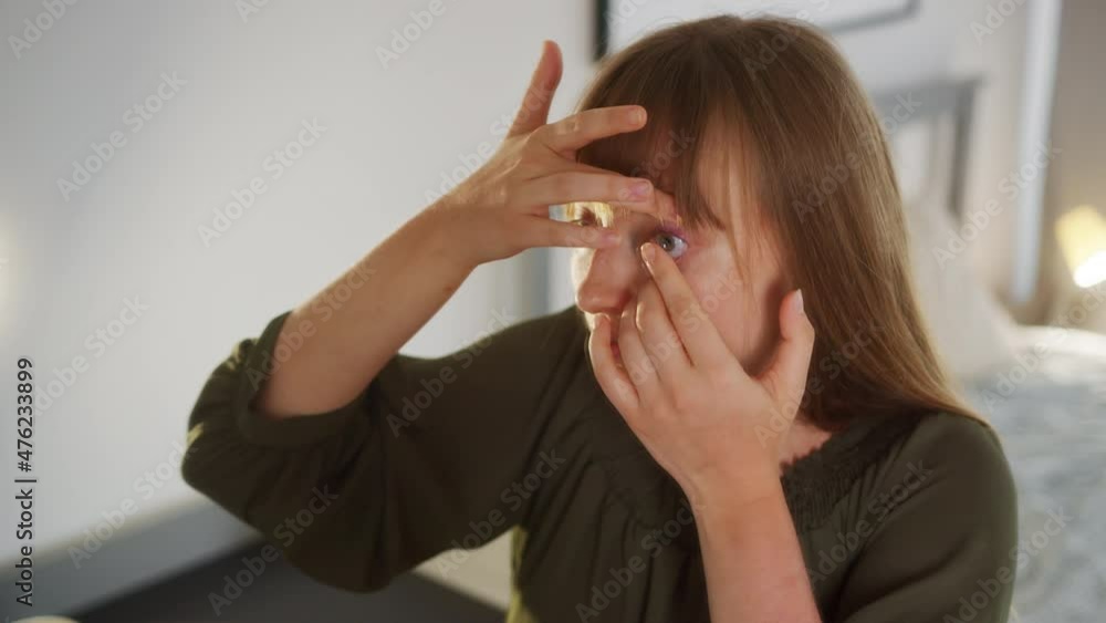 Young Woman Placing Contact Lens on Her Eye in Front of Mirror, Close Up. Vision Correction Device, Full Frame Young Woman Placing Contact Lens on Her Eye in Front of Mirror, Close Up. Vision Correction Device, Full Frame