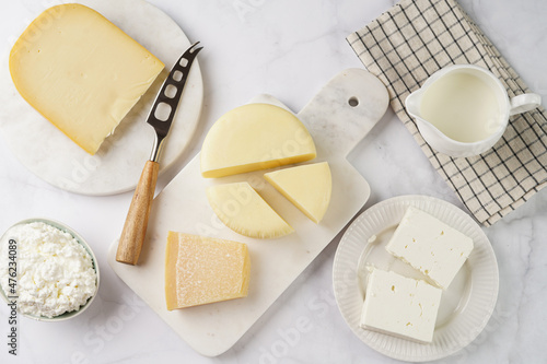 Various cheese types on marble and porcelain plates - ingredients for traditional georgian open pie khachapuri photo