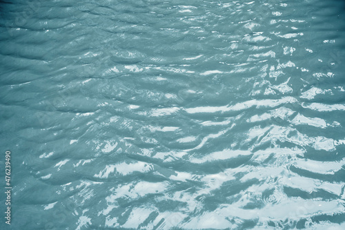 Water surface with ripples and sunlight reflections