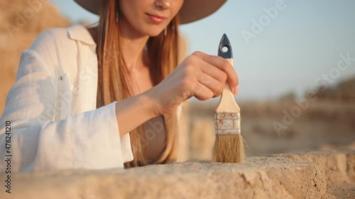 Archeological Excavation. Hand of Archaeologist With Tools (Brush) Sweep. Archaeological Digging Site: Great Female Archeologist Work on Excavation Site, Cleaning Cultural Artifacts with Brush. photo