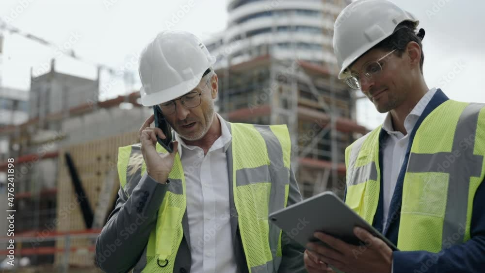 Two engineers using tablet and mobile on construction site Two engineers using tablet and mobile on construction site
