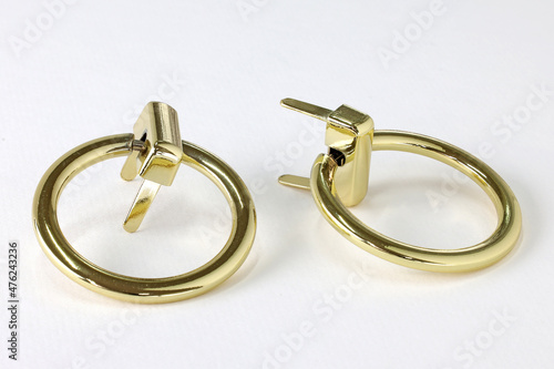 Metal ring for the bag. Sliding gold mount. Rings for attaching the handle of the bag on a white background. Gold-colored bag accessories.