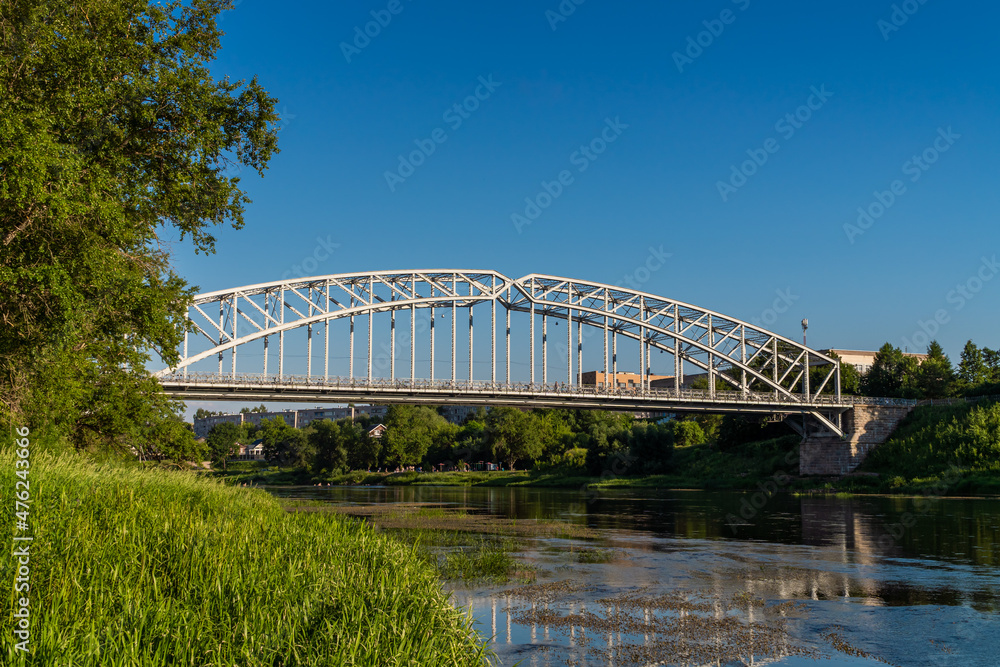 Naklejka premium Russia. June 20, 2021. Pedestrian arch bridge over the Msta River in Borovichi.