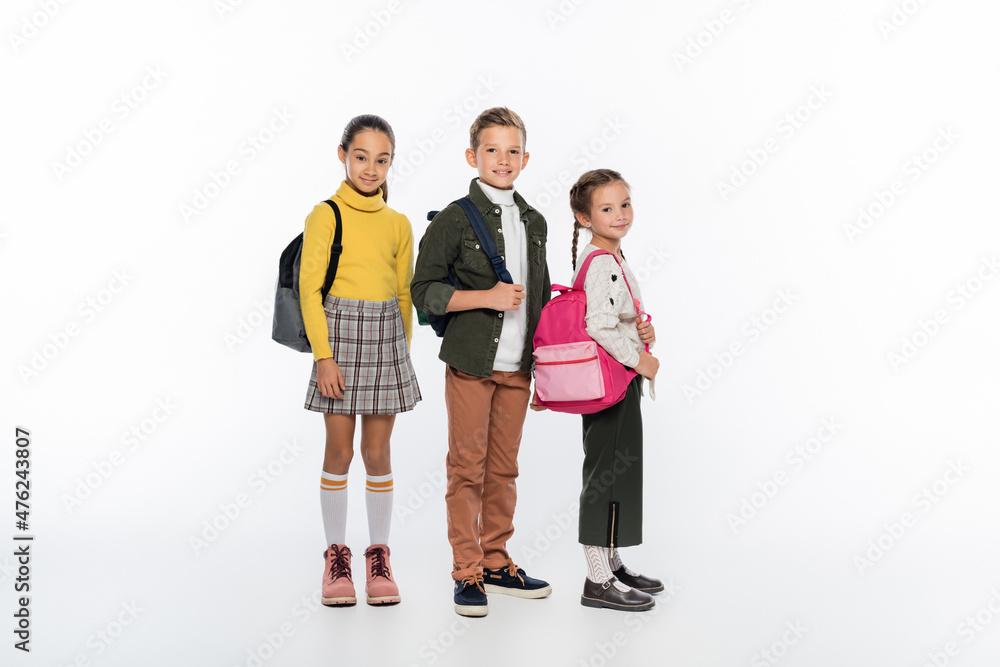 cheerful schoolboy and schoolgirls standing with backpacks on white. cheerful schoolboy and schoolgirls standing with backpacks on white.