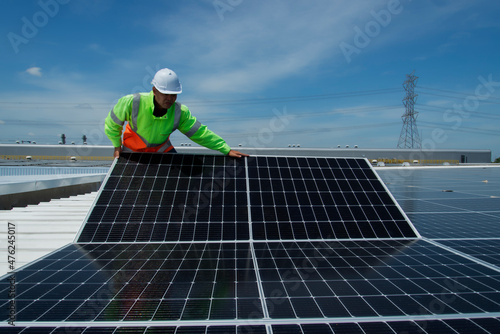 Asian man engineer service check installation solar cell on the roof of factory.