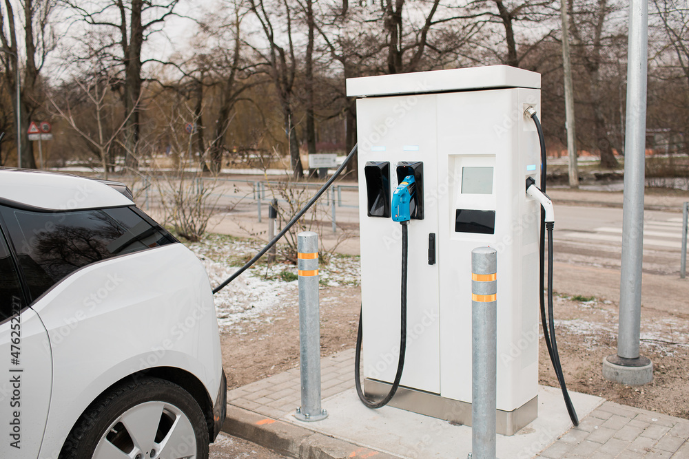 Sustainable green electric energy car. Electric car charging in winter. Smart city transport. Future charge station for environment and save the planet. Sustainable green electric energy car. Electric car charging in winter. Smart city transport. Future charge station for environment and save the planet.