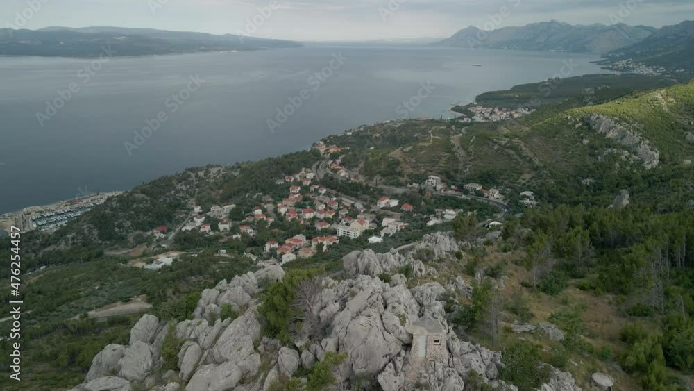 Drone view of a small town in the Makarska Riviera region in Croatia, with the stunning Adriatic Sea and the island of Brac in the background. Drone view of a small town in the Makarska Riviera region in Croatia, with the stunning Adriatic Sea and the island of Brac in the background.
