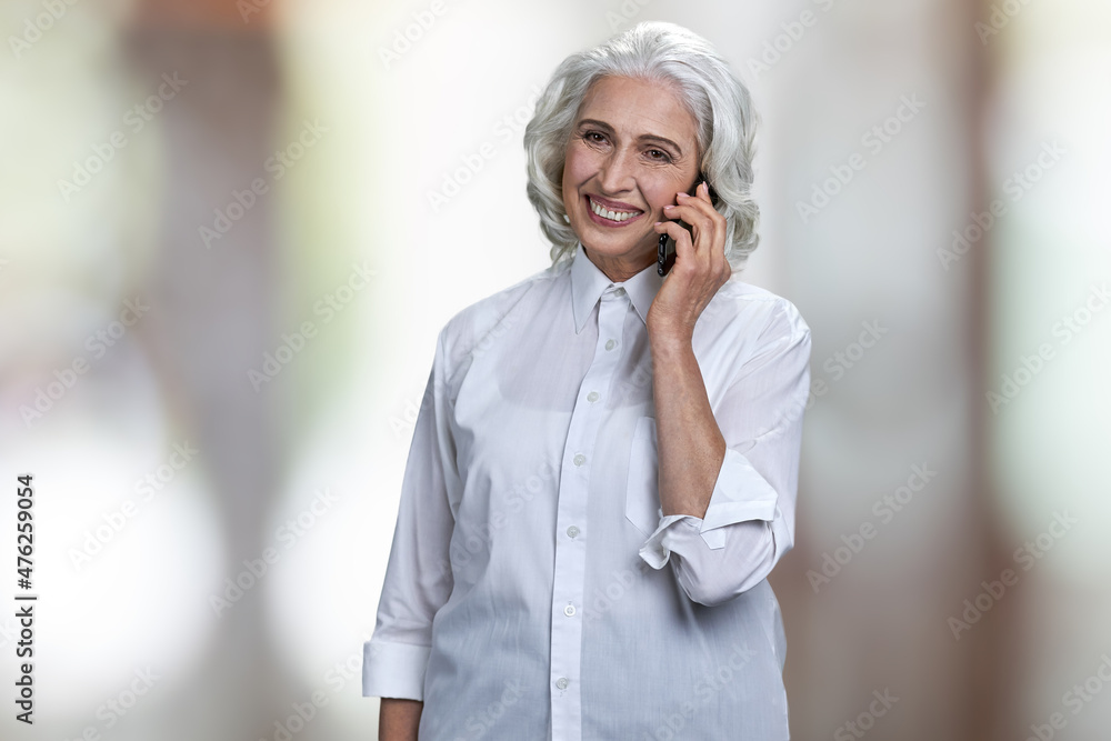 Portrait of cheerful mature business lady talking on mobile phone. Portrait of cheerful mature business lady talking on mobile phone.