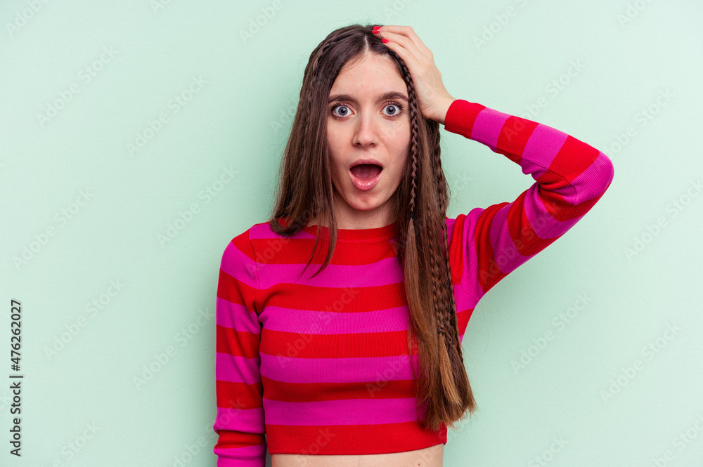 Fototapeta premium Young caucasian woman isolated on green background being shocked, she has remembered important meeting.