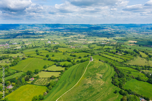 Glastonbury tor filmed from drone on sunny day, footage was taken from dji mavic pro 2 drone, iconic monument in the middle of the countryside