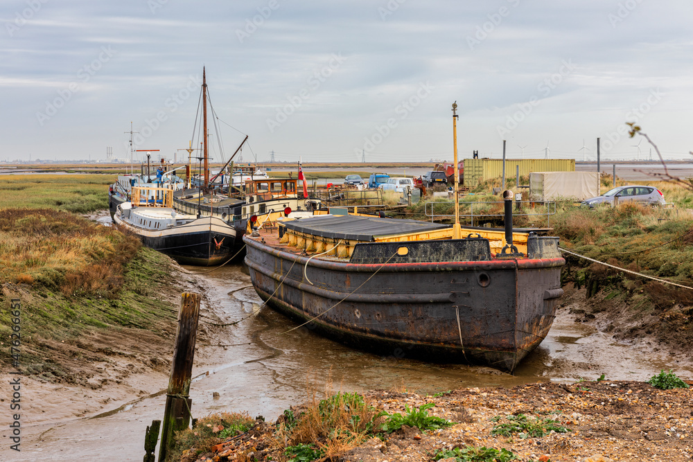 Barges and Boats grounded at Low Tide on the River Medway Estuary at Upchurch in Kent, England