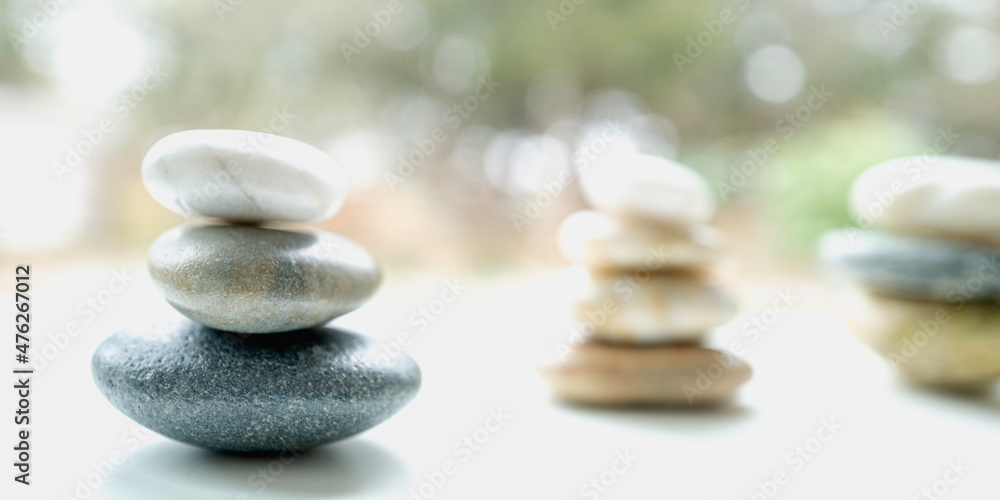 Bright soft macro photography of Zen rocks stacked on the white promenade in the woods