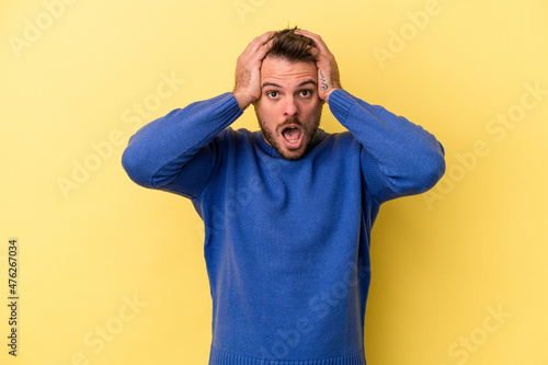 Young caucasian man isolated on yellow background being shocked, she has remembered important meeting.