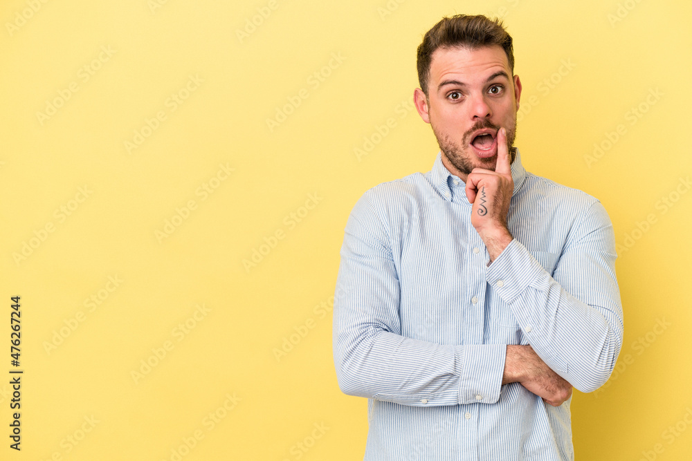Young caucasian man isolated on yellow background looking sideways with doubtful and skeptical expression. Young caucasian man isolated on yellow background looking sideways with doubtful and skeptical expression.