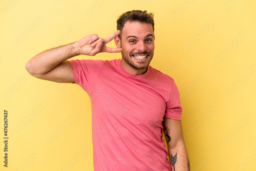 Obraz premium Young caucasian man isolated on yellow background dancing and having fun.