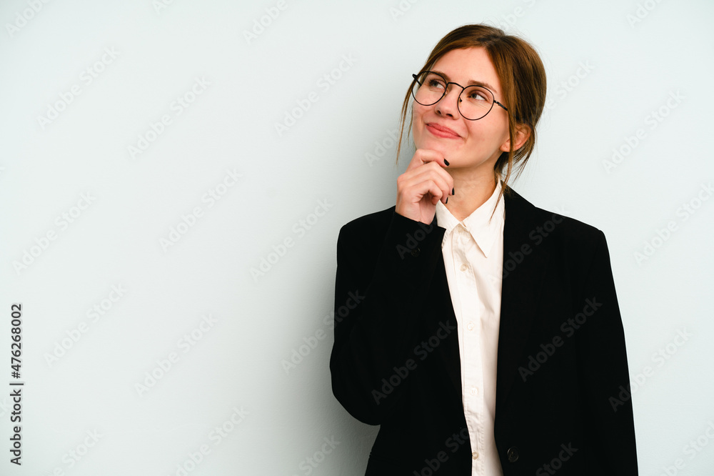 Young business English woman isolated on blue background looking sideways with doubtful and skeptical expression. Young business English woman isolated on blue background looking sideways with doubtful and skeptical expression.
