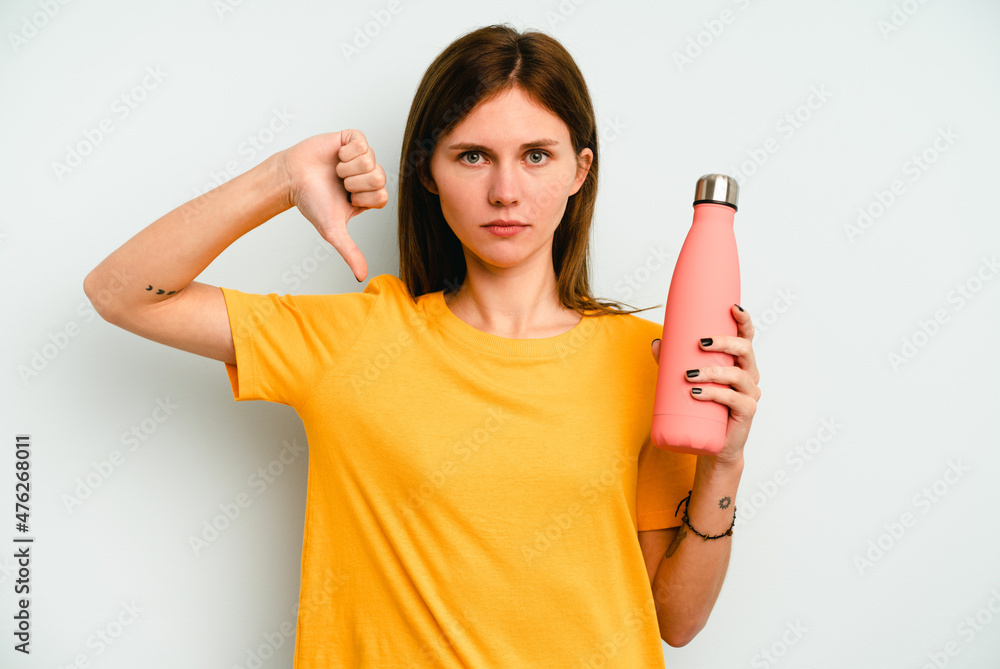 Young English woman holding a thermo isolated on blue background showing a dislike gesture, thumbs down. Disagreement concept. Young English woman holding a thermo isolated on blue background showing a dislike gesture, thumbs down. Disagreement concept.