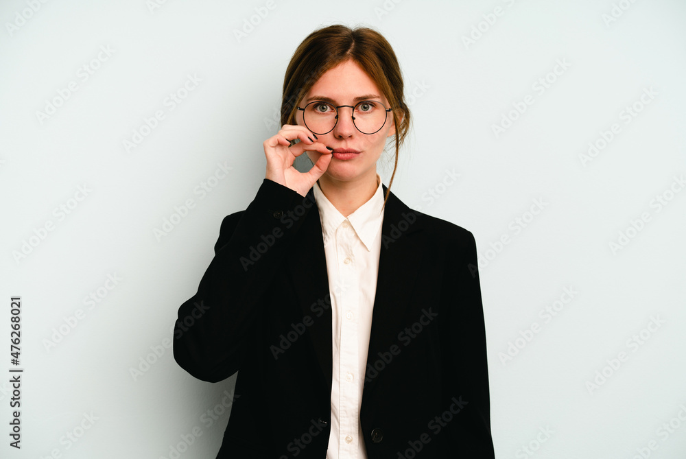Young business English woman isolated on blue background with fingers on lips keeping a secret. Young business English woman isolated on blue background with fingers on lips keeping a secret.