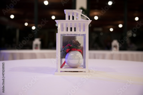 Decorazione natalizia a forma di lanterna contenente palla di natale bianca photo