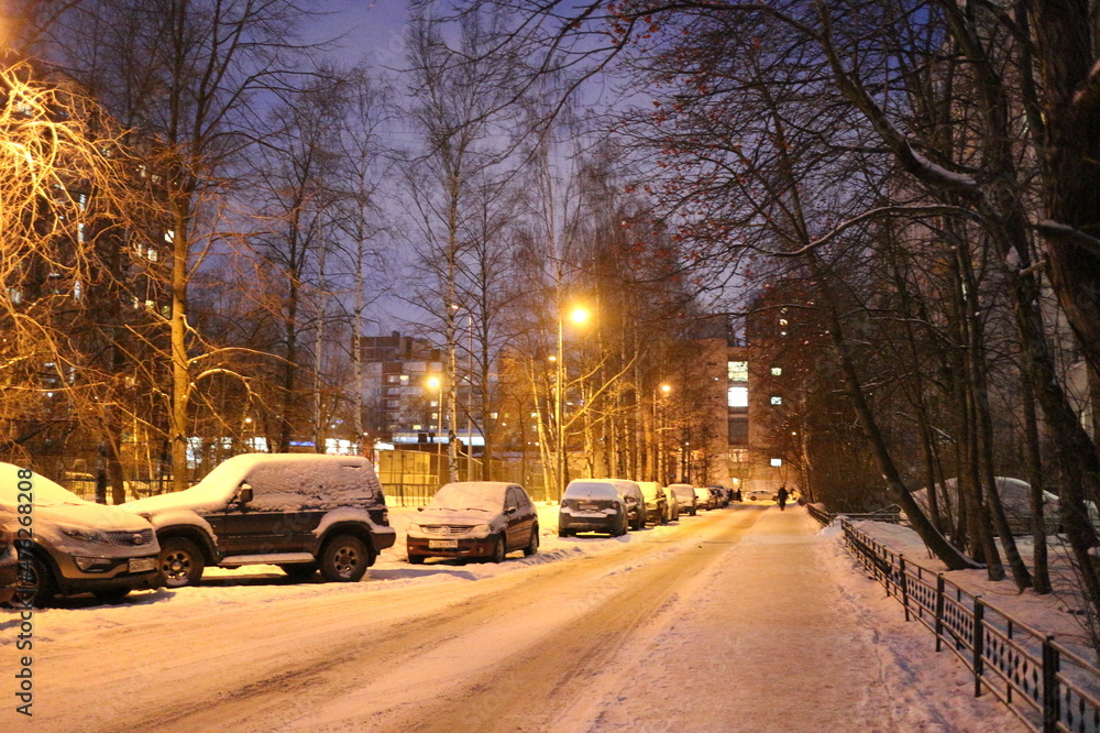 Snowy road in a city quarter on a winter evening