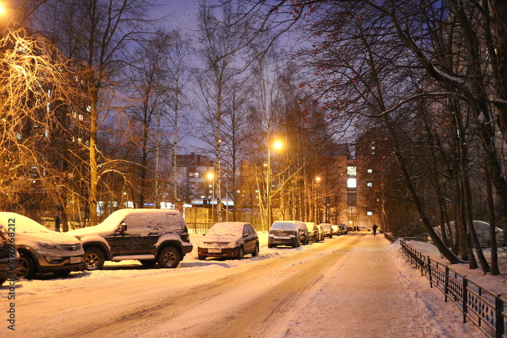 Snowy road in a city quarter on a winter evening