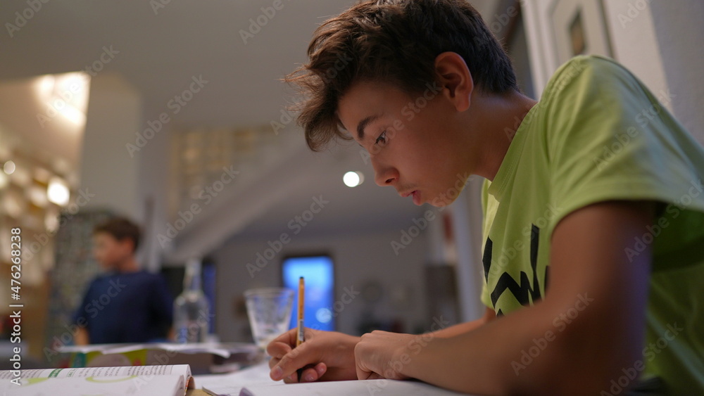 Young boy doing homework after school. Kid preparing for exam Young boy doing homework after school. Kid preparing for exam