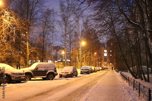 Snowy road in a city quarter on a winter evening