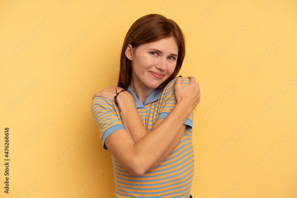 Young English woman isolated on yellow background hugs, smiling carefree and happy. Young English woman isolated on yellow background hugs, smiling carefree and happy.