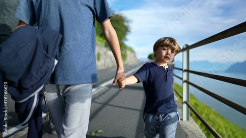 Tow children holding hands, brother holding little sibling hand